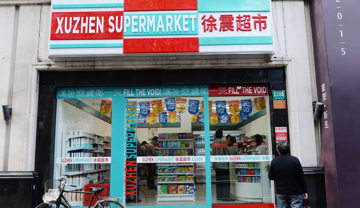 Seorang wanita berdiri di luar Supermarket Xu Zhen di Shanghai, Cina, (13/4). Supermarket dengan slogan "mengisi kekosongan" ini hanya menjual produk kosong, dibuka sejak 8 April di Changning (Reuters/Stringer)