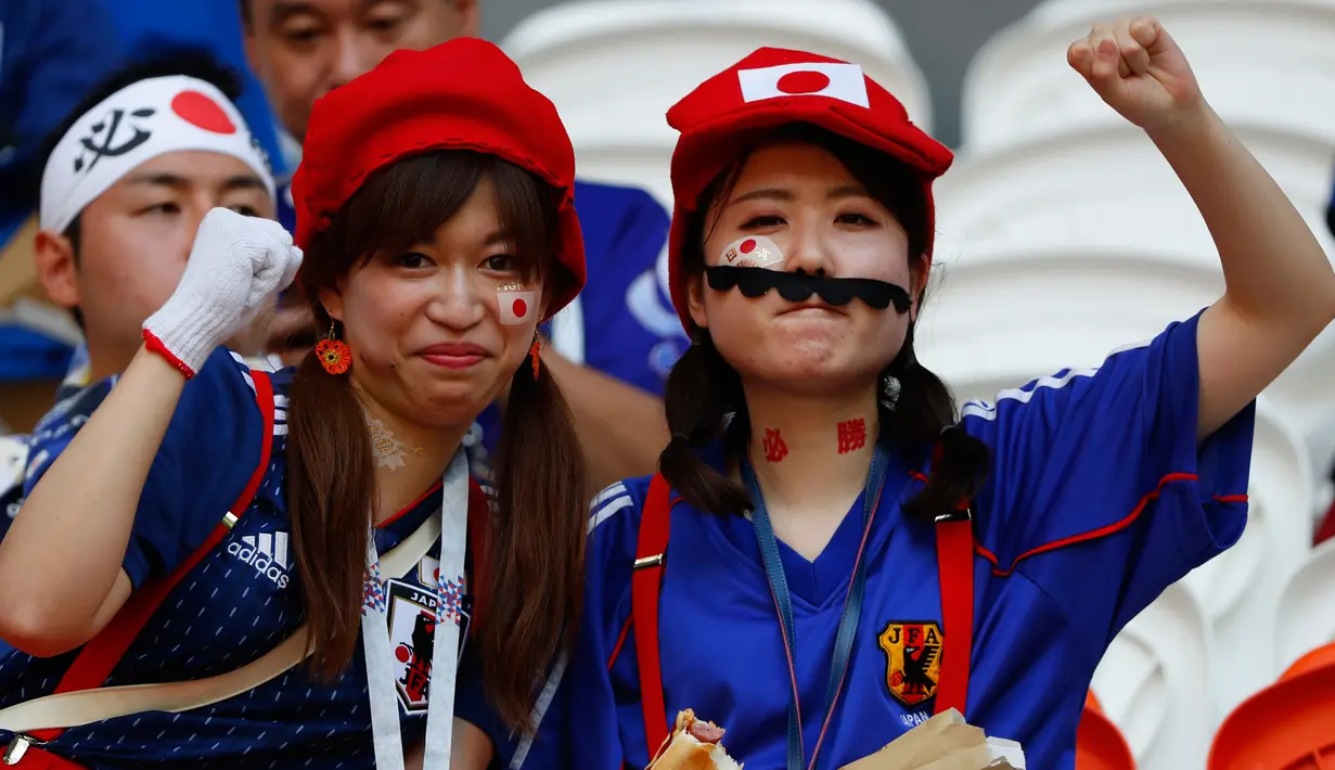 Dua suporter wanita mengenakan atribut unik sebelum pertandingan grup H Piala Dunia 2018 melawan Kolombia di Mordovia Arena di Saransk, Rusia (19/6). Para suporter tim samurai biru ini tampil unik saat mendukung negaranya berlaga. (AFP Photo/Jack Guez)