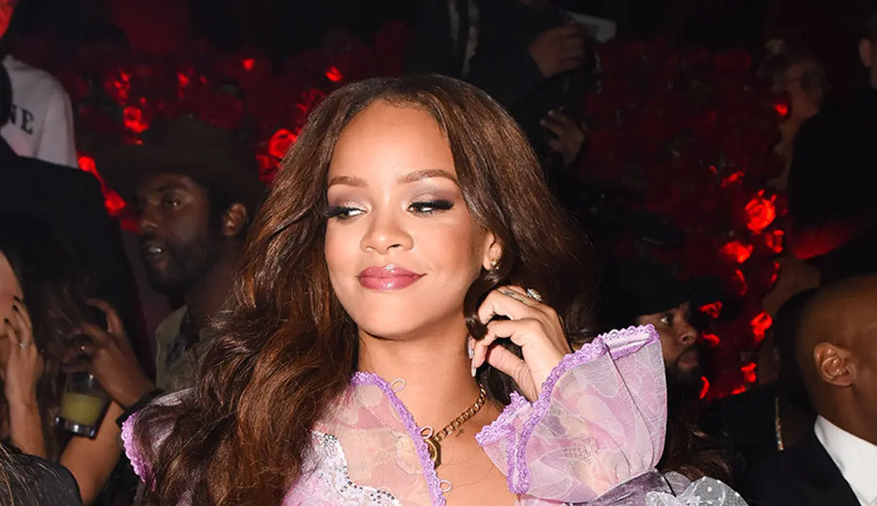 Dengan mini dress transparan berwarna pink, Rihanna pun dengan sengaja memamerkan tubuhnya.  (REX/Shutterstock/HollywoodLife)