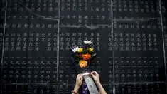 Seikat bunga diletakkan di monumen yang berisi nama-nama orang yang gugur dalam pertempuran melawan Jepang saat Perang Dunia II di Nanjing, (3/9/2014). (AFP PHOTO/STR)