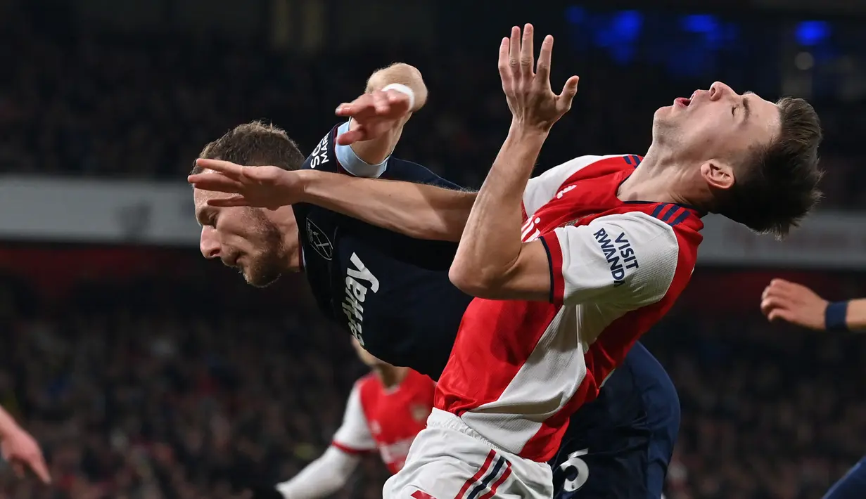 Bek West Ham United Vladimir Coufal (kiri) bersaing dengan bek Arsenal Kieran Tierney dalam laga pekan 17 Liga Inggris di Emirates Stadium, Kamis dini hari WIB (16/12/2021). Arsenal sukses kalahkan tamunya West Ham dengan skor 2-0. (Ben STANSALL/AFP)