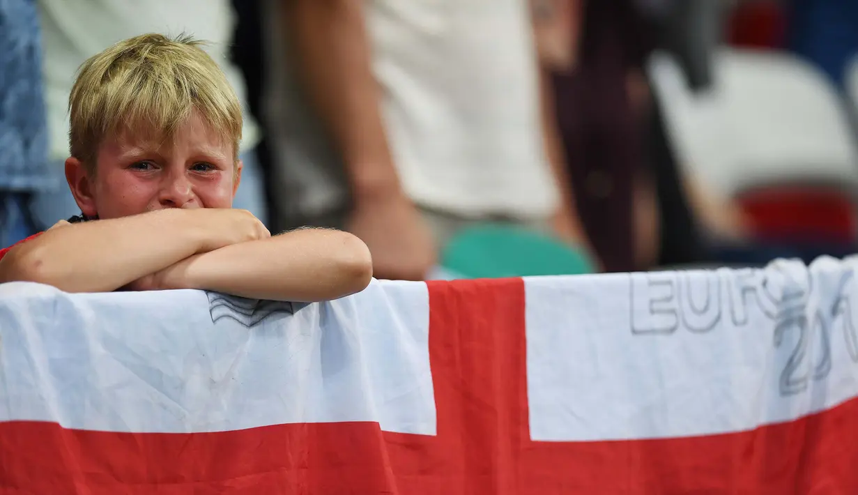 Kesedihan suporter cilik asal Inggris saat timnya kalah dari Islandia di Stadion Allianz Riviera, Nice (27/6/2016). (AFP/Paul Ellis)
