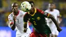 Bek Kamerun, Ernest Mabouka, berebut bola dengan gelandang Burkina Faso, Prejuce Nakoulma, pada laga Grup A Piala Afrika di Stade de l'Amitie Sino-Gabonaise, Gabon, Sabtu (14/1/2017). Kedua negara bermain imbang 1-1. (AFP/Gabriel Bouys)