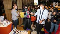 Menteri Parekraf Sandiaga Uno melihat salah satu karya pada acara AKI 2021 di Gandaria City, Jakarta, Kamis (9/12/2021). Program AKI yang berjalan dengan pendampingan dan mentoring mampu tingkatkan pendapatan peserta UMKM 10 kali lipat. (Liputan6.com/Fery Pradolo)