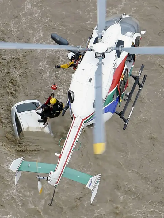 Tim penyelamat menggunakan helikopter untuk mengevakuasi warga yang terjebak luapan banjir dari Sungai Kinugawa di Joso, prefektur Ibaraki, Jepang, Kamis (10/9). Satu orang hilang dan lebih dari 90 ribu warga diperintahkan untuk mengungsi. (REUTERS/Kyodo)