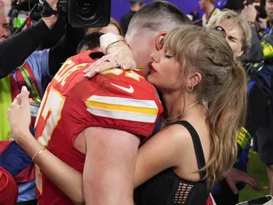 Pemain Kansas City Chiefs, Travis Kelce (kiri) berpelukan dengan kekasihnya sekaligus penyanyi top dunia, Taylor Swift setelah memenangkan Super Bowls LVIII di Las Vegas, Amerika Serikat, Minggu (11/02/2024) waktu setempat. Kansas City Chiefs menang atas San Francisco 49ers dengan skor 25-22 melalui babak tambahan. (AP Photo/John Locher)