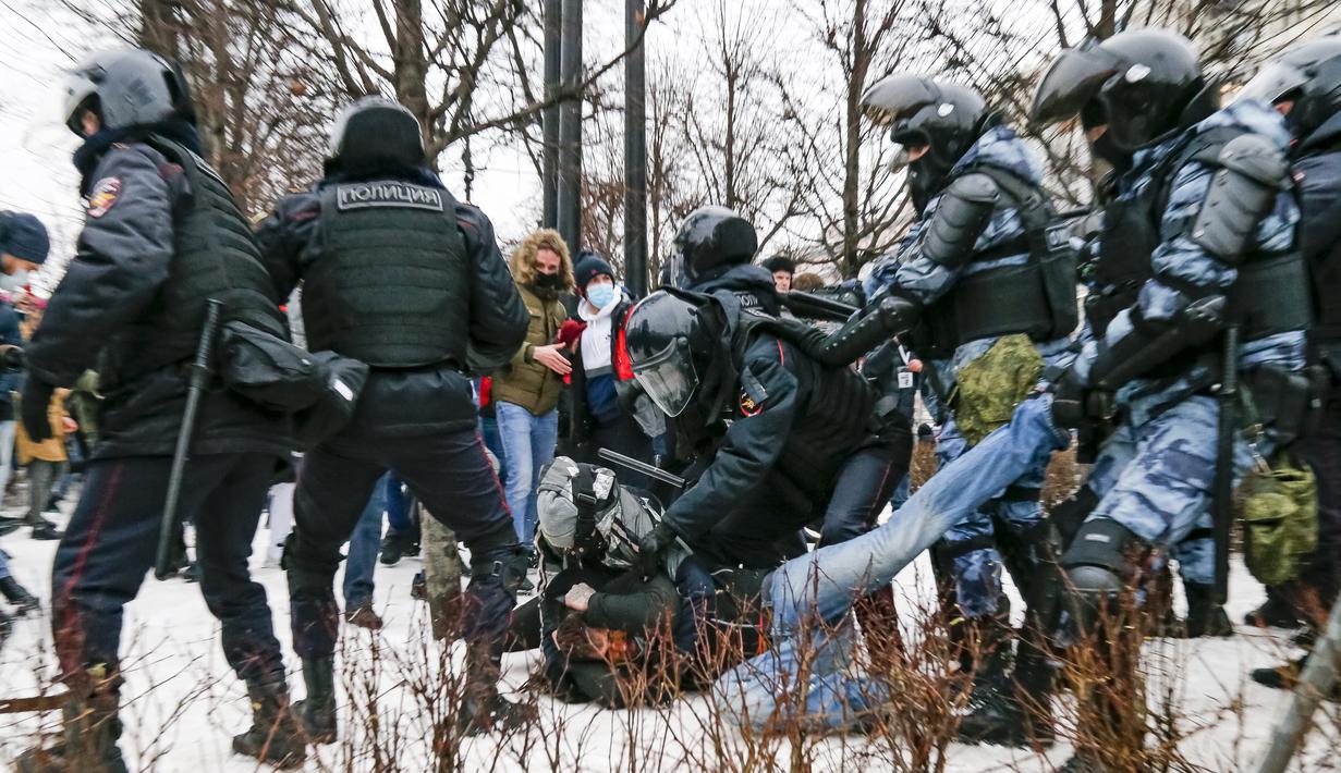 Polisi anti huru hara menahan seorang demonstran dengan wajah berdarah selama protes terhadap pemenjaraan pemimpin oposisi Alexei Navalny di alun-alun Pushkin di Moskow, Rusia, Sabtu (23/1/2021). (AP Photo/Alexander Zemlianichenko)
