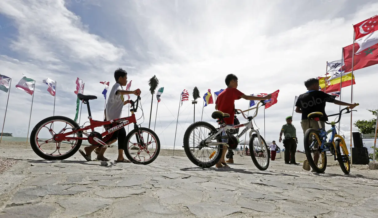 Anak-anak bermain sepeda dekat garis finish balapan Tour de Singkarak 2016 di Padang Pariaman, Sumatera Barat, (10/8/2016). (Bola.com/Nicklas Hanoatubun)