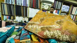 Pekerja merapikan kain lokal di Pasar Baru, Jakarta, Selasa (24/3/2015). Pengusaha tekstil nasional meminta Presiden Jokowi untuk melakukan kerja sama dengan Uni Eropa dan Turki agar bisa meningkatkan ekspor tekstil nasional.(Liputan6.com/Faizal Fanani)