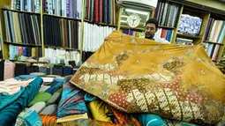 Pekerja merapikan kain lokal di Pasar Baru, Jakarta, Selasa (24/3/2015). Pengusaha tekstil nasional meminta Presiden Jokowi untuk melakukan kerja sama dengan Uni Eropa dan Turki agar bisa meningkatkan ekspor tekstil nasional.(Liputan6.com/Faizal Fanani)