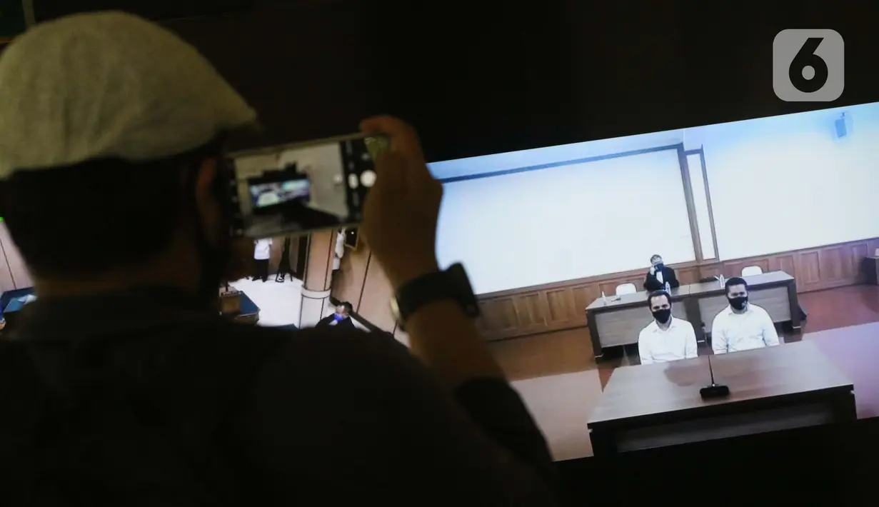 Pewarta merekam layar monitor yang menampilkan dua terdakwa penyiraman air keras terhadap penyidik KPK Novel Baswedan, Rahmat Kadir Mahulette (kanan) dan Rony Bugis yang mengikuti sidang putusan secara teleconference di PN Jakarta Utara, Kamis (16/7/2020). (Liputan6.com/Helmi Fithriansyah)