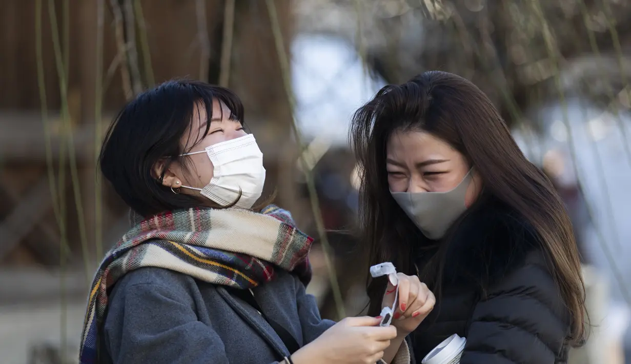 Kana Morita (kiri)dengan temannya Azusa Marushima, bereaksi setelah dia menemukan dia menerima keberuntungan luar biasa "daikichi" dalam meramal saat mereka mengunjungi kuil Yushima Tenmangu di Tokyo pada Hari Tahun Baru, Jumat (1/1/2021). (AP Photo/Hiro Komae)