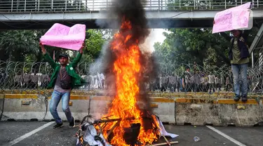 Sejumlah elemen mahasiswa menggelar demo dengan membakar ban bekas di kawasan Patung Kuda, Jakarta Pusat, Selasa (13/9/2022). Demo tersebut untuk menolak kebijakan pemerintah menaikkan harga bahan bakar minyak (BBM). (Liputan6.com/Johan Tallo)