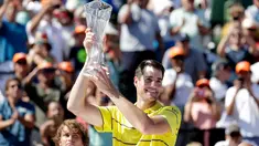 Petenis AS, John Isner memegang trofi seusai meraih gelar juara Miami Terbuka 2018 di Key Biscayne, Minggu (1/4). Pada laga final yang menegangkan tersebut, Isner sukses menaklukkan petenis Jerman Alexander Zverev 6-7, 6-4, 6-4. (AP/Lynne Sladky)