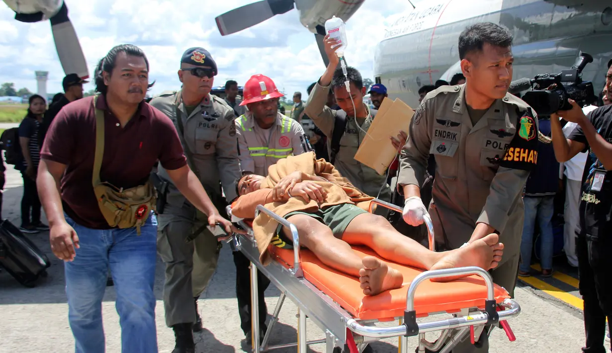 Korban selamat dari serangan Kelompok Kriminal Bersenjata (KKB) tiba di bandara di Timika, Papua, Kamis (6/12). Hingga hari ini, TNI-Polri telah menemukan 16 jenazah yang diduga merupakan pekerja PT Istaka Karya. (AP Photo/Mujiono)