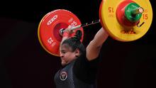Lifter Indonesia, Nurul Akmal saat melakukan angkatan snatch di Angkat Besi Olimpiade Tokyo 2020 (AFP)