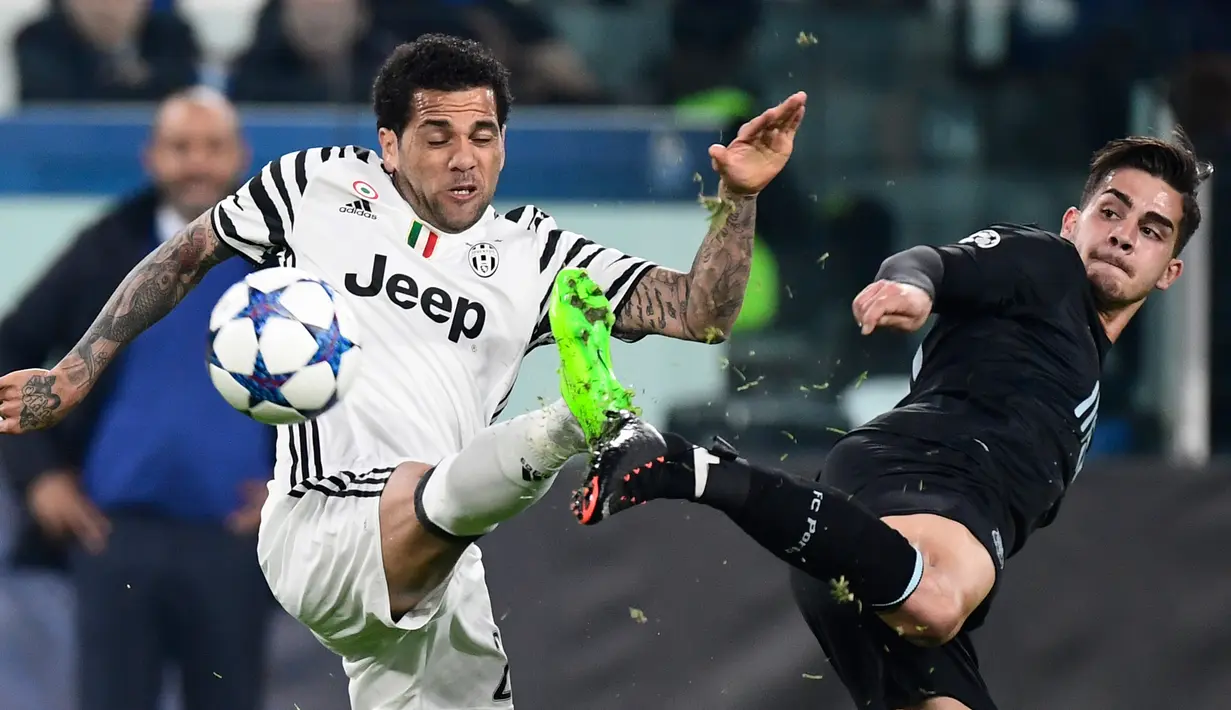 Bek Juventus, Dani Alves (kiri) berebut bola dengan penyerang Porto, Andre Silva pada leg kedua babak 16 besar Liga Champions di Stadion Juventus, Turin, Italia, (15/3). Juventus menang atas Porto dengan skor 1-0. (AFP Photo/Miguel Medina)