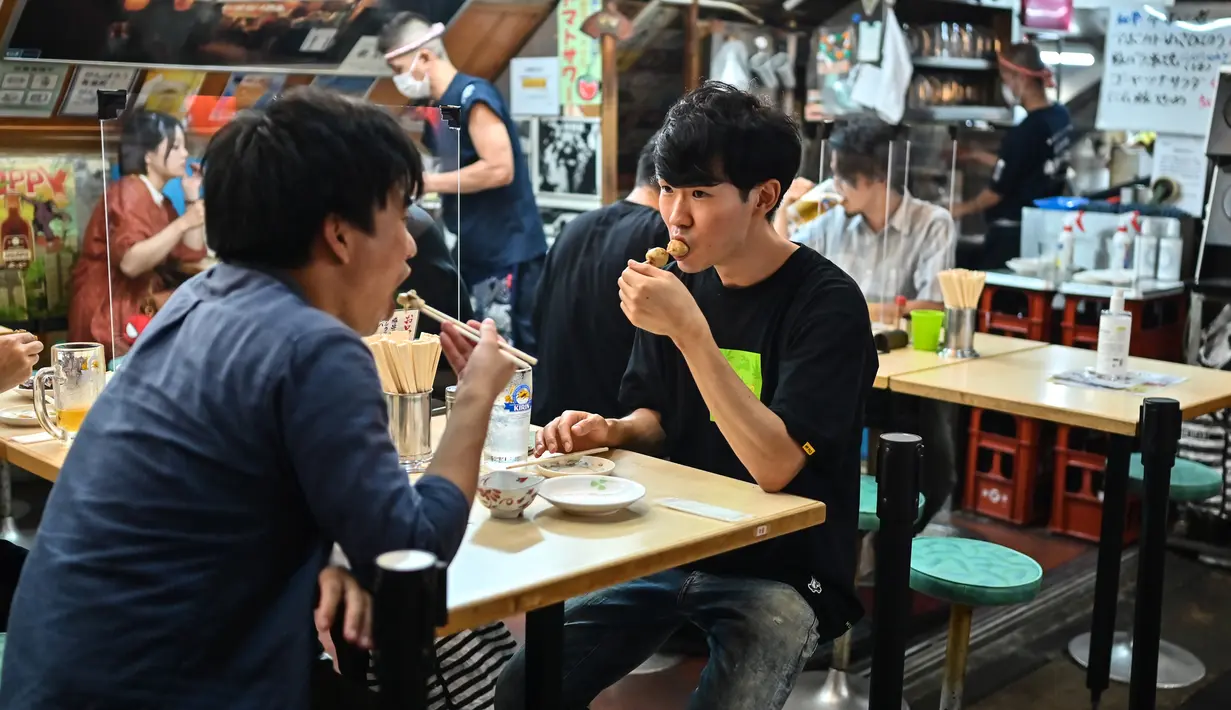Orang-orang berkumpul di "izakaya", sebuah bar tradisional Jepang, pada malam hari di Tokyo, 4 September 2020. Interior tempat ini biasanya dari kayu, yang semakin menambah kesan tradisional. (Photo by Charly TRIBALLEAU / AFP)
