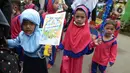 Sejumlah murid TK Islam membawa poster di Jalan Raya Radjiman Widyo Ningrat, Jakarta, Sabtu (26/3/2022). Pemerintah telah memperbolehkan melaksanakan kewajiban selama bulan suci Ramadan dengan protokol kesehatan yang ketat. (merdeka.com/Imam Buhori)