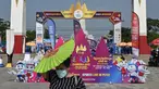 Seorang wanita memegang kipas angin untuk melindungi dirinya dari sinar matahari di luar Stadion Nasional Morodok Techo, Phnom Penh, Jumat 5 Mei 2023. (NHAC NGUYEN/AFP)