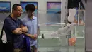 Dua pria melihat robot yang digunakan dalam operasi bawah laut selama China International Robot Show di Shanghai (10/7/2019). Pameran yang menghadirkan robot-robot canggih ini diselenggarakan dari 10 sampai 13 Juli 2019. (AFP Photo/STR)
