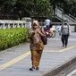 Sejumlah pekerja berjalan usai bekerja di Jalan Jenderal Sudirman, Jakarta, Selasa (10/5/2022). Pemerintah mengimbau masyarakat menerapkan bekerja dari rumah atau work from home (WFH) selama satu hingga dua pekan ke depan untuk mengantisipasi penyebaran virus corona COVID-19 usai libur Lebaran 2022. (Liputan6.com/Faizal Fanani)