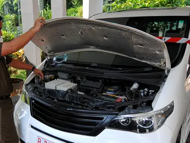 Petugas memeriksa mobil listrik yang terparkir di Gedung Kejaksaan Agung, Jakarta, Rabu (24/6/2015). Penyidik Kejagung menyita sepuluh mobil listrik hasil pengadaan proyek gagal yang digagas mantan Menteri BUMN Dahlan Iskan. (Liputan6.com/Yoppy Renato)  