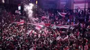 Suporter River Plate mengibarkan bendera saat merayakan gelar juara Copa Libertadores di Obelisk, Buenos Aires, Argentina, Minggu (9/12). River Plate merebut gelar juara Copa Libertadores usai menaklukkan Boca Juniors. (AP Photo/Gustavo Garello)