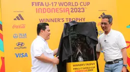 Ketua PSSI, Erick Thohir (kiri), bersama Penjabat (Pj) Gubernur DKI Jakarta, Heru Budi Hartono, memamerkan trofi Piala Dunia U-17 2023 kepada masyarakat di Bundaran Hotel Indonesia (HI), Jakarta, Minggu (15/10/2023). (Bola.com/Bagaskara Lazuardi)