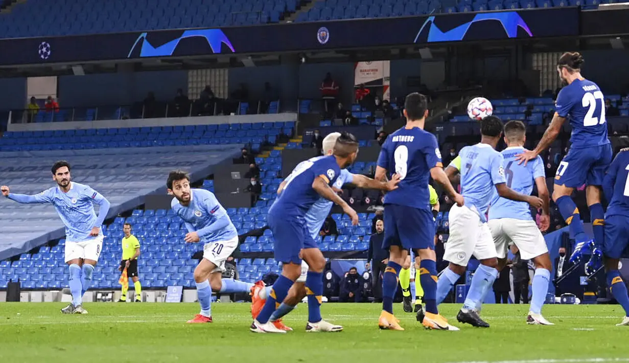 Gelandang Manchester City, Ilkay Gundogan, mencetak gol melalui tendangan bebas ke gawang FC Porto pada laga Liga Champions di Stadion  Etihad, Kamis (22/10/2020). City menang dengan skor 3-1. (Laurence Griffiths/Pool via AP)