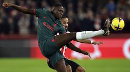 Penyerang Liverpool, Ibrahima Konate berebut bola dengan pemain Brentford, Bryan Mbeumo pada pertandingan lanjutan Liga Inggris di di Gtech Community Stadium di London, Selasa (3/1/2023). Brentford menang atas Liverpool dengan skor 3-1. (AP Photo/Ian Walton)