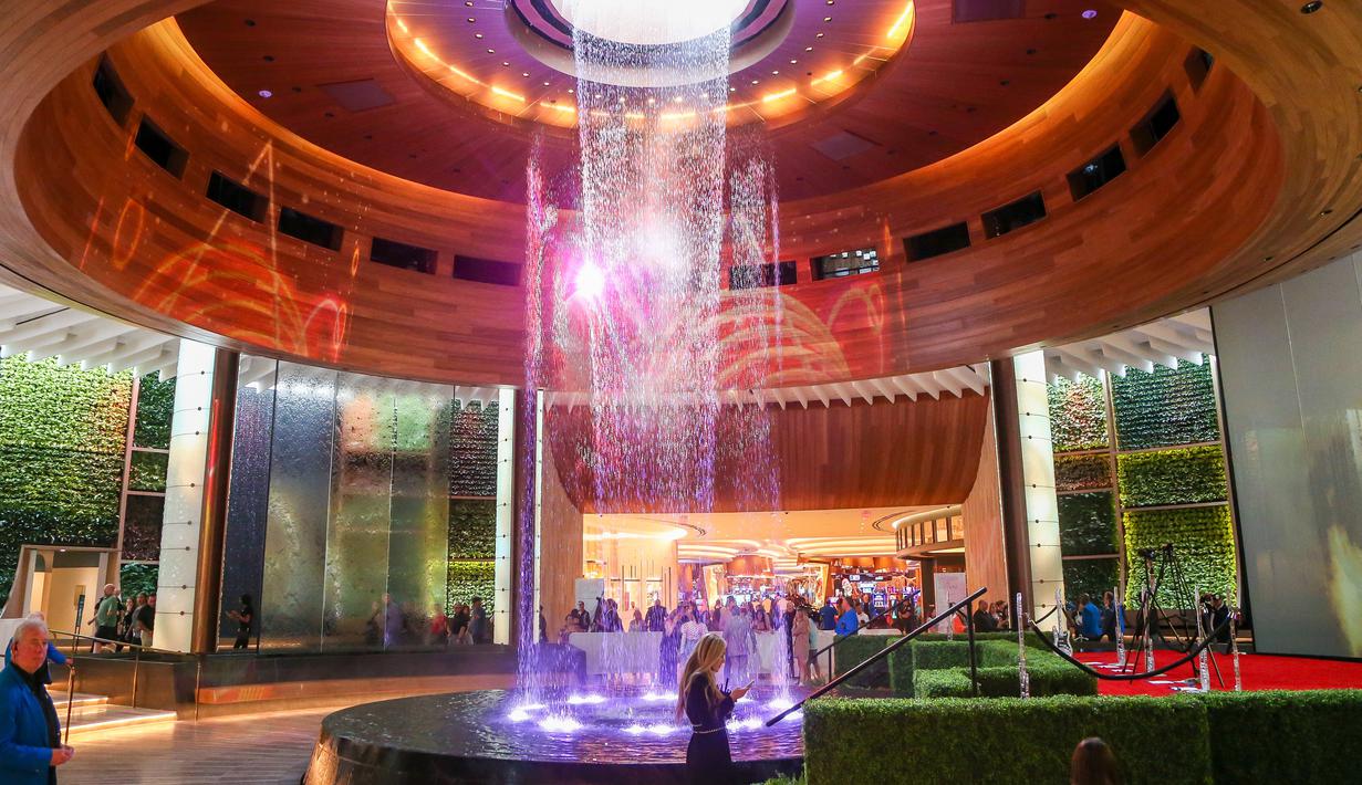 Orang-orang berdiri dekat 'The Oculus' ketika mereka menghadiri grand opening Seminole Hard Rock Hotel & Casino di Hollywood, Florida, Amerika Serikat, Kamis (24/10/2019). Seminole Hard Rock Hotel & Casino dilengkapi sekitar 3000 mesin slot, 193 meja permainan serta 46 meja poker. (Zak BENNETT/AFP)