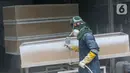 Pekerja mengecat peti mati Covid-19 di Rawa Mekar Jaya, Serpong, Tangerang Selatan, Kamis (21/01/2021). Produksi peti mati berbahan baku papan MDF meningkat cukup tinggi sejak bulan November 2020. (Liputan6.com/Fery Pradolo)