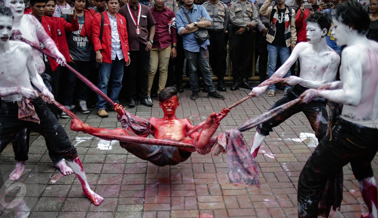 Massa Gerakan Mahasiswa Nasional Indonesia (GMNI) melakukan teaterikal saat aksi bela Indonesia terkait Freeport di depan Kantor PT. Freeport Indonesia, Jakarta, Jumat (24/2). (Liputan6.com/Faizal Fanani)