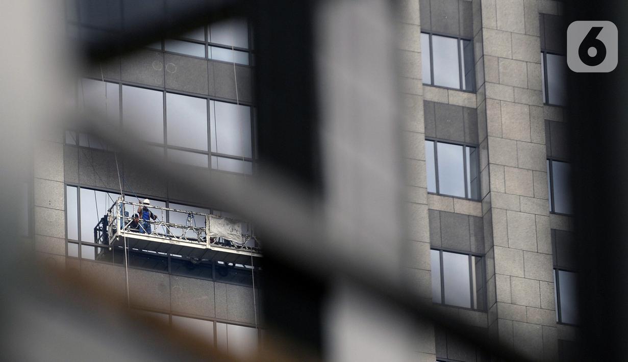 Pekerja membersihkan kaca gedung bertingkat di kawasan Sudirman Central Business District (SCBD), Jakarta, Senin (8/6/2020). Hampir tiga bulan kebijakan work from home (WFH) akibat pandemi COVID-19, banyak gedung bertingkat tidak terawat hari ini mulai dibersihkan. (merdeka.com/Dwi Narwoko)