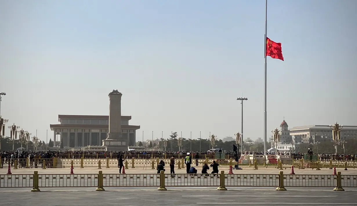 Bendera nasional China berkibar setengah tiang di Lapangan Tiananmen selama peringatan nasional tiga menit untuk memperingati orang yang meninggal dalam wabah coronavirus COVID-19, di Beijing (4/4/2020). (AFP/Leo Ramirez)