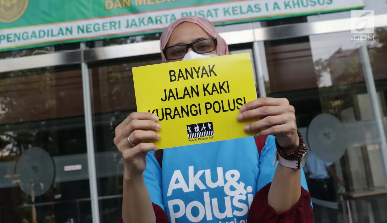 Aktivis membentangkan tulisan saat menunggu proses pengajuan gugatan warga untuk menuntut hak mendapatkan udara bersih di Pengadilan Negeri Jakarta Pusat, Kamis (4/7/2019). Mereka mengajukan gugatan warga negara kepada tujuh pihak tergugat. (Liputan6.com/Helmi Fithriansyah)