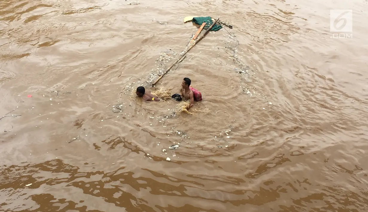 Anak-anak berenang di aliran Sungai Ciliwung yang meluap di Rawajati, Jakarta, Selasa (6/2). Meluapnya Sungai Ciliwung akibat intensitas hujan yang tinggi. (Liputan6.com/Immanuel Antonius)