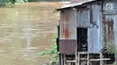 Seorang anak belajar di rumahnya di bantaran Kali Ciliwung, Jakarta, Minggu (3/3). Bencana banjir kiriman masih menjadi ancaman warga bantaran Kali Ciliwung, terlebih saat hujan deras terus mengguyur kawasan hulu di Bogor. (merdeka.com/Iqbal S. Nugroho)