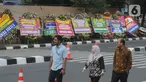 Pejalan kaki melintasi karangan bunga ucapan selamat yang berjejer di sekitar Gedung Merah Putih KPK, Jakarta, Jumat (20/12/2019). Papan karangan bunga tersebut berisi ucapan selamat terhadap dilantiknya pimpinan KPK periode 2019-2023. (merdeka.com/Imam Buhori)