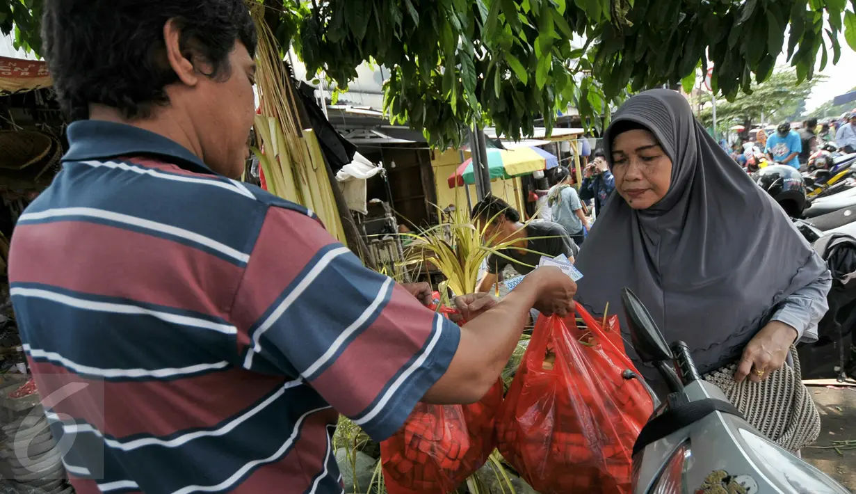 Warga membeli kulit ketupat untuk bahan membuat ketupat yang menjadi makanan khas di Hari Raya Idul Fitri, Jakarta, Senin (4/7). Jelang Hari Raya Idul Fitri, pedagang kulit ketupat mulai kebajiran pembeli. (Liputan6.com/Yoppy Renato)