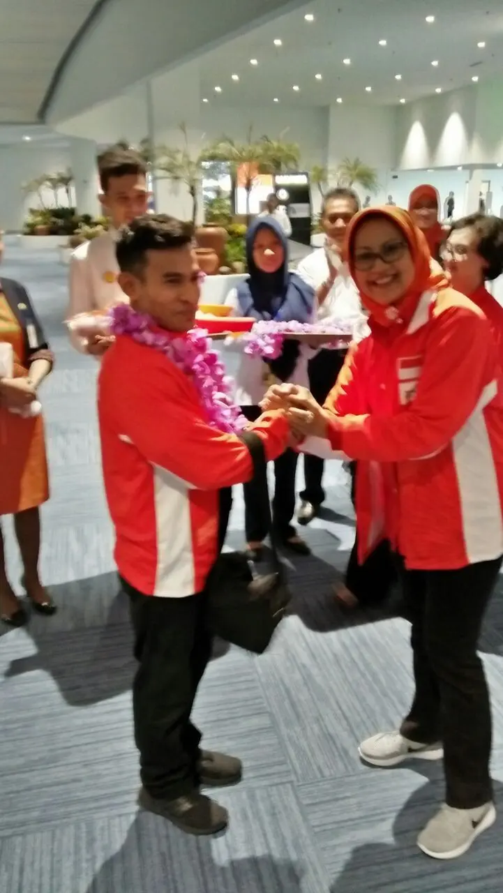 Ketua PB Persani, Ilya Avianti memberikan ucapan selamat kepada atlet senam putra, Dwi Samsul Arifin, saat penyambutan di Bandara Soetta, Kamis (22/8/2017). (Dok. Persani)