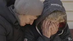 Seorang tetangga menghibur Natalya, yang suami dan keponakannya terbunuh oleh pasukan Rusia, saat dia menangis di kebunnya di Bucha, Ukraina, Senin, 4 April 2022. (AP Photo/Vadim Ghirda)