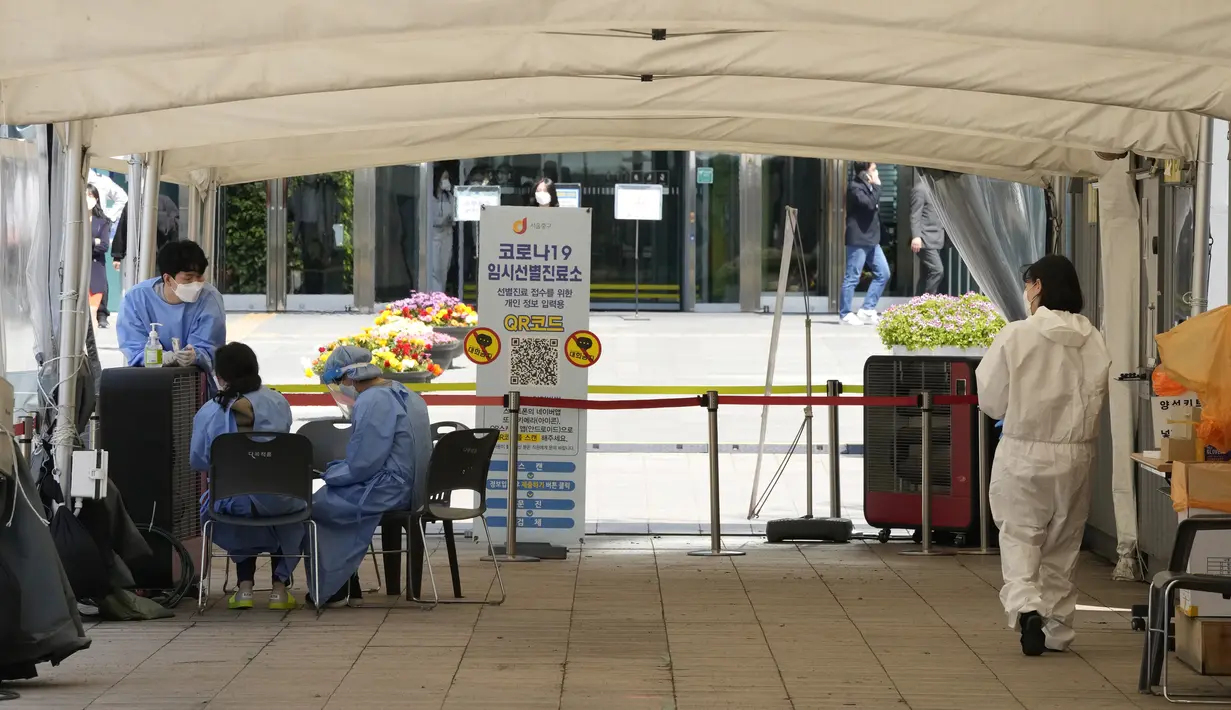 Pekerja medis menunggu orang-orang di pusat pengujian COVID-19 sementara di Seoul, Korea Selatan, Jumat (15/4/2022). Korea Selatan atau Korsel akan menghapus sebagain besar pembatasan covid-19 mulai pekan depan menyusul lonjakan kasus Omicron yang mulai berkurang. (AP Photo/Ahn Young-joon)