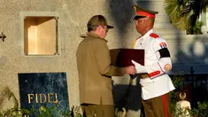 Presiden Kuba, Raul Castro (kiri) menerima kotak kayu berisi abu mantan Presiden Kuba, Fidel Castro saat akan dimakamkan di peristirahatan terakhir di Santa Ifigenia Cemetery, di Santiago, Kuba (4/12). (REUTERS/ACN/Marcelino Vazquez)