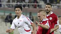 Striker Korea Utara, Han Kwang-Song (kiri) berusaha merebut bola yang dibawa pemain Lebanon Robert Melki selama grup E Piala Asia 2019 di Stadion Sharjah (17/1/2019). Pemain 20 tahun merupakan target lama Si Nyonya Tua semenjak Januari tahun lalu. (AFP Photo/Karim Sahib)