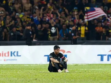 Kiper Timnas U-22 Satria Tama duduk termenung setelah pertandingan Sepak Bola Indonesia melawan Malaysia di Stadion Shah Alam, Selangor, Sabtu (26/08). Indonesia kalah 0-1 dari tuan rumah Malaysia di Sea Games 2017. (Liputan6.com/Faizal Fanani)