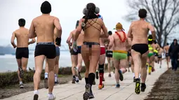 Peserta berlari saat mengikuti lomba Underpants Run di tepi sungai Danube di Beograd, Serbia (4/2). Dengan hanya mengenakan pakaian dalam para peserta tetap semangat mengikuti lomba dengan suhu mendekati nol derajat Celcius. (AFP Photo/Andrej Isakovic)