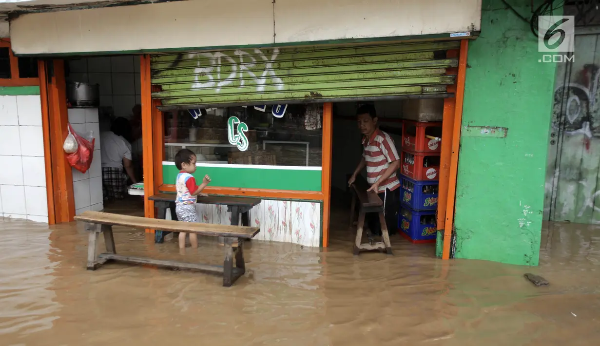 Warga beraktivitas saat banjir merendam Jalan Jatinegara Barat, Jakarta Timur, Selasa (6/2). Deras dan tingginya debit air di Kali Ciliwung membuat Jalan Jatinegara Barat terputus. (Liputan6.com/Arya Manggala)