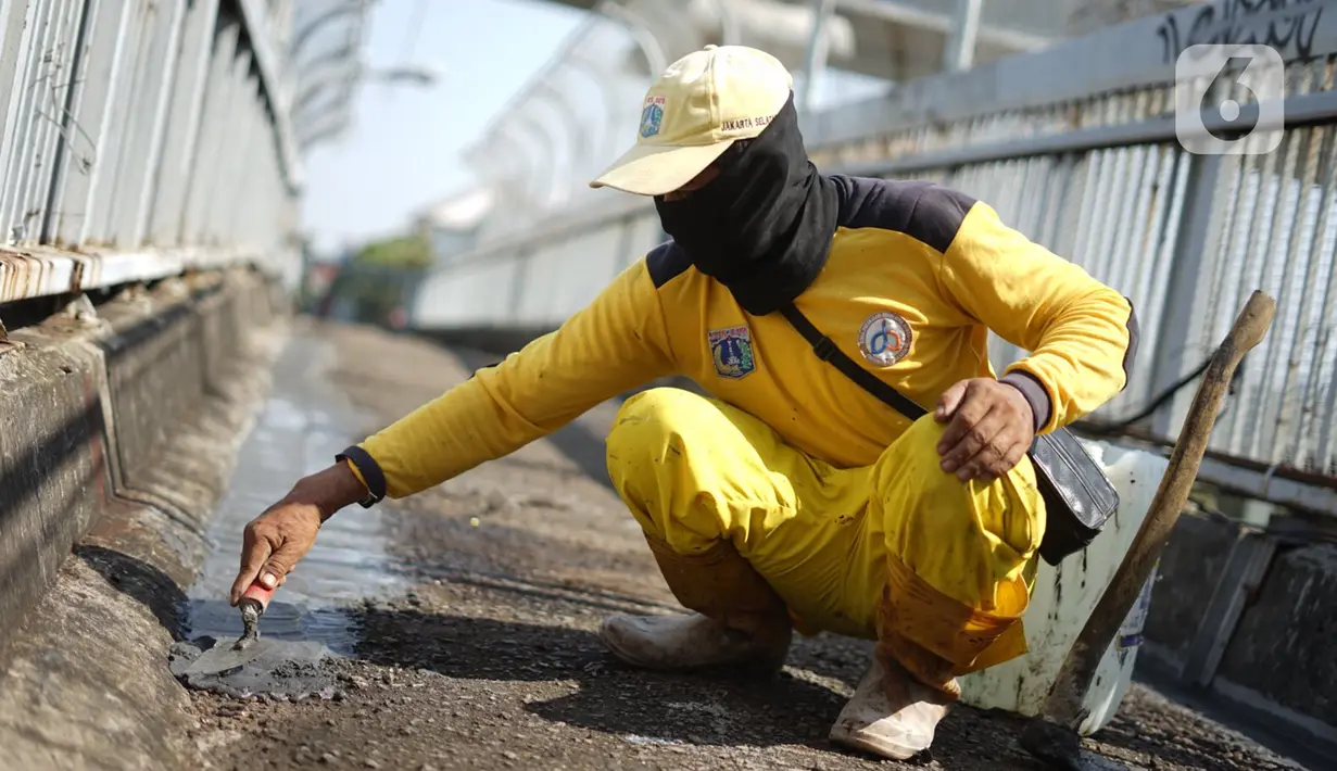 Petugas Bina Marga memerbaiki lantai Jembatan Penyeberangan Orang (JPO) yang berlubang di kawasan Tebet, Jakarta, Kamis (27/8/2020). Perbaikan dilakukan guna meningkatkan kenyamanan bagi pejalan kaki yang melintas. (Liputan6.com/Immanuel Antonius)